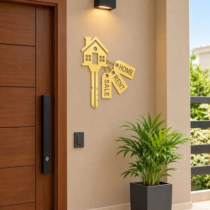 Black house key wall sticker with Home, Rent and Sale tags mounted on a cream wall beside a wooden entrance door.